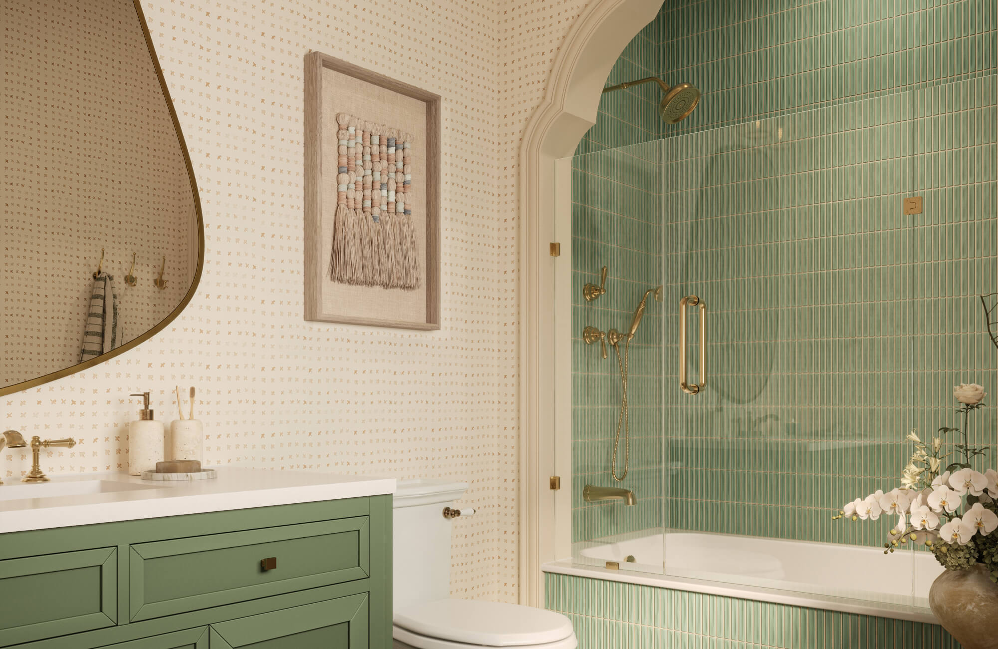 Bright modern bathroom with green vertical subway tile shower, patterned wallpaper, brass fixtures, wall art, and green vanity.