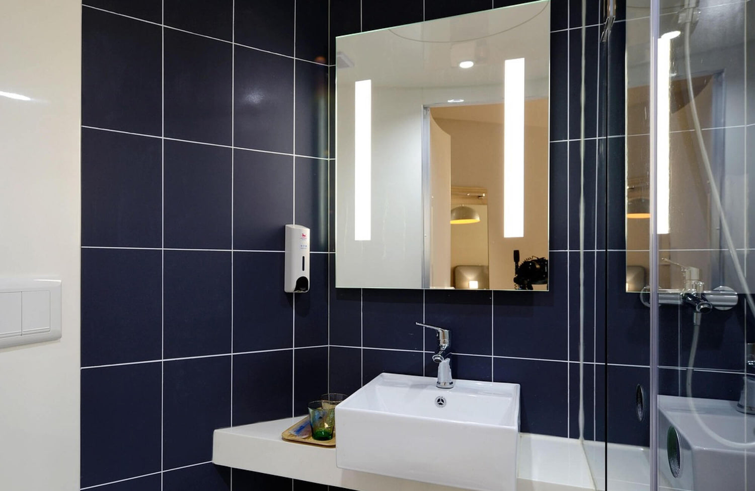 Elegant modern bathroom featuring a round frameless mirror with a sleek beveled edge, reflecting soft ambient lighting that enhances the room’s airy atmosphere.