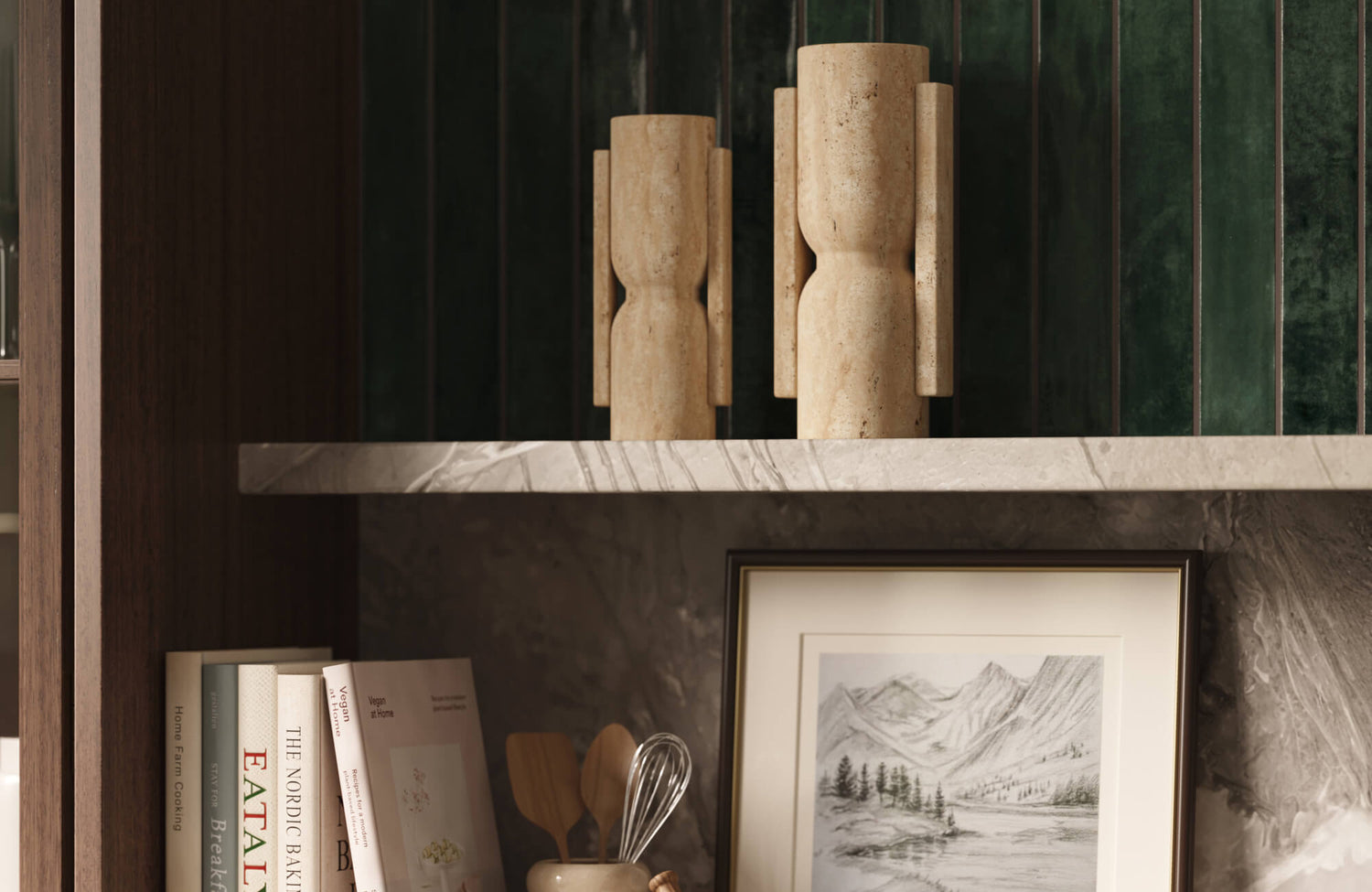Modern organic kitchen detail with glossy forest green vertical subway tile wall, marble shelf, wood cabinetry, and sculptural stone decorative vases.