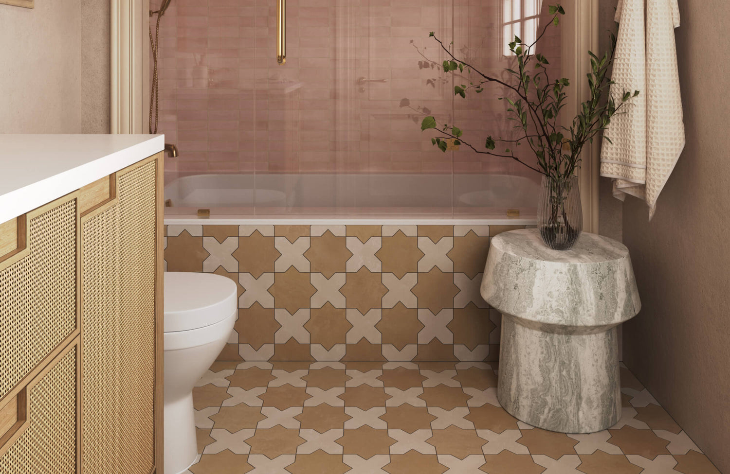 Small bathroom designed with warm patterned floor and tub surround tiles, soft blush shower wall tiles behind clear glass, a woven-front vanity, and natural stone accents that create a cozy yet refined spa-inspired atmosphere.