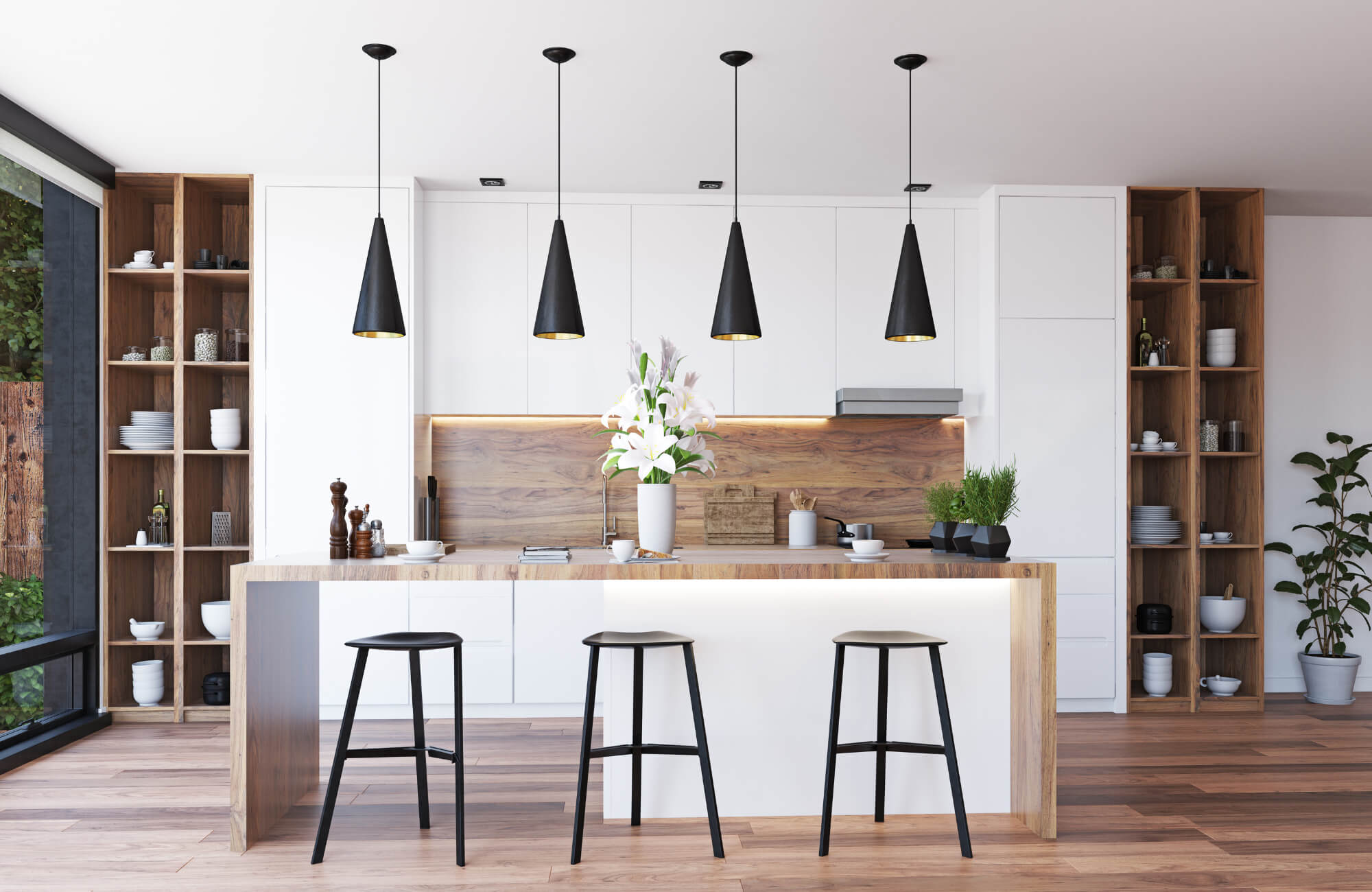 Modern kitchen with white cabinetry, wood accents, black pendant lights, and natural light from a large window beside the island.