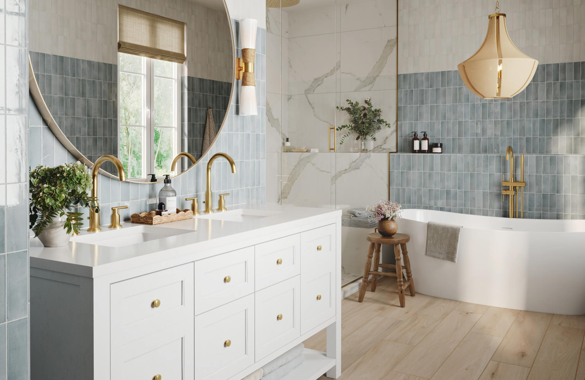 Bright bathroom featuring elegant vertical blue wall tiles, a large round mirror flanked by modern gold-and-white sconces, a white double vanity with brushed gold fixtures, and a sculptural pendant light above a freestanding tub.