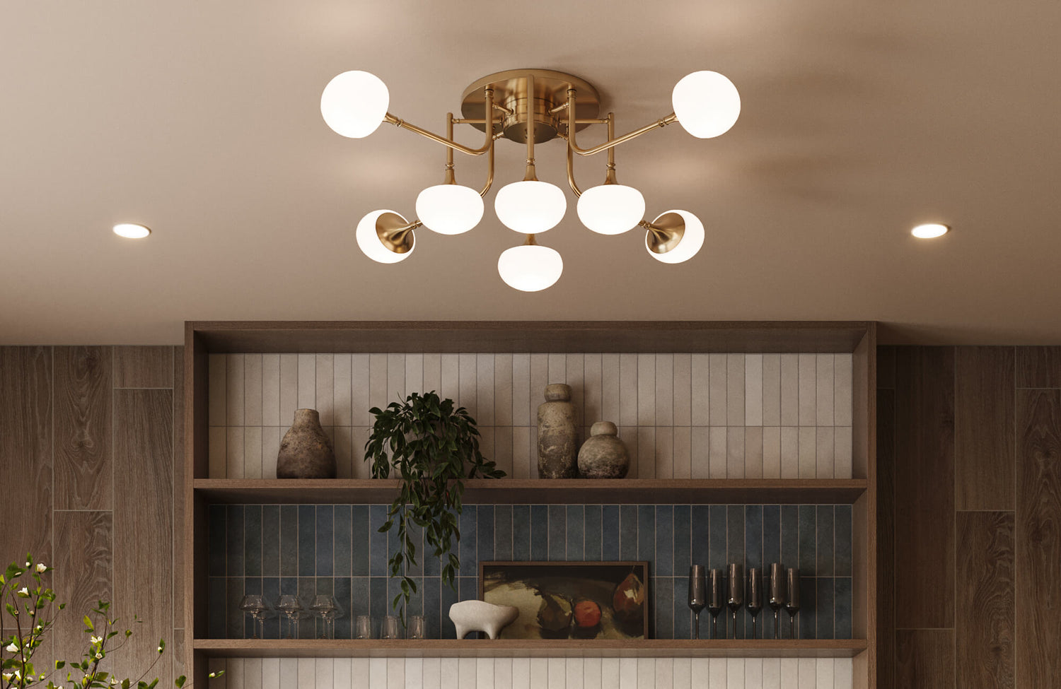 Mid century modern brass chandelier with glowing globe bulbs above built-in shelving, vertical tile, and warm wood accents.