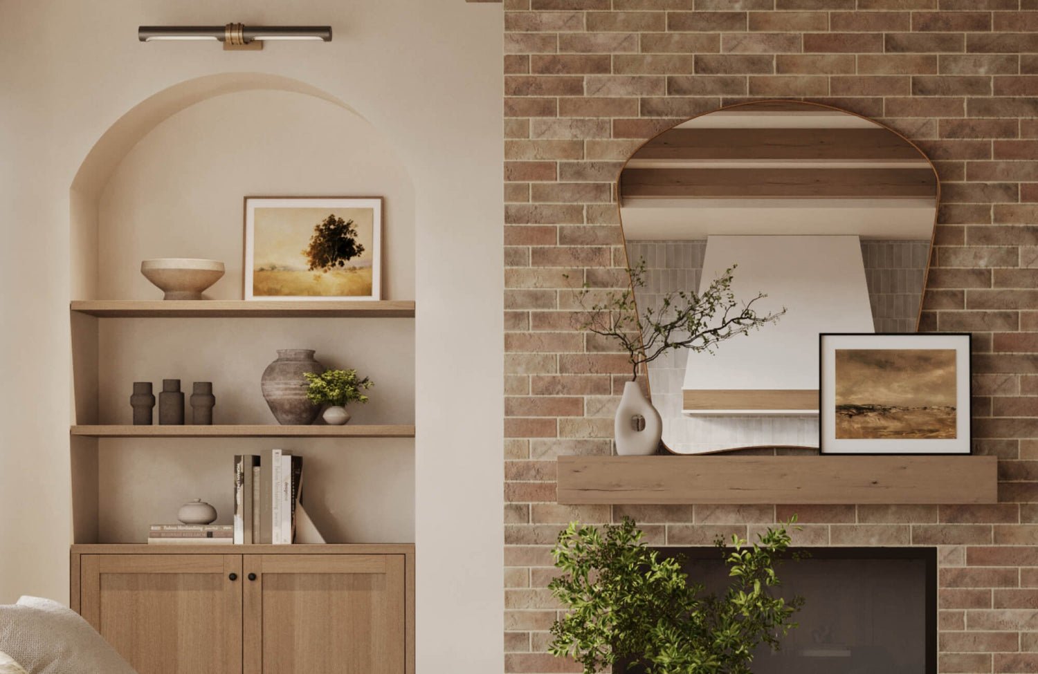 A warm contemporary living room features framed landscape artwork displayed on built-in shelving and a fireplace mantel, creating visual balance through layered textures, soft neutrals, and natural materials.