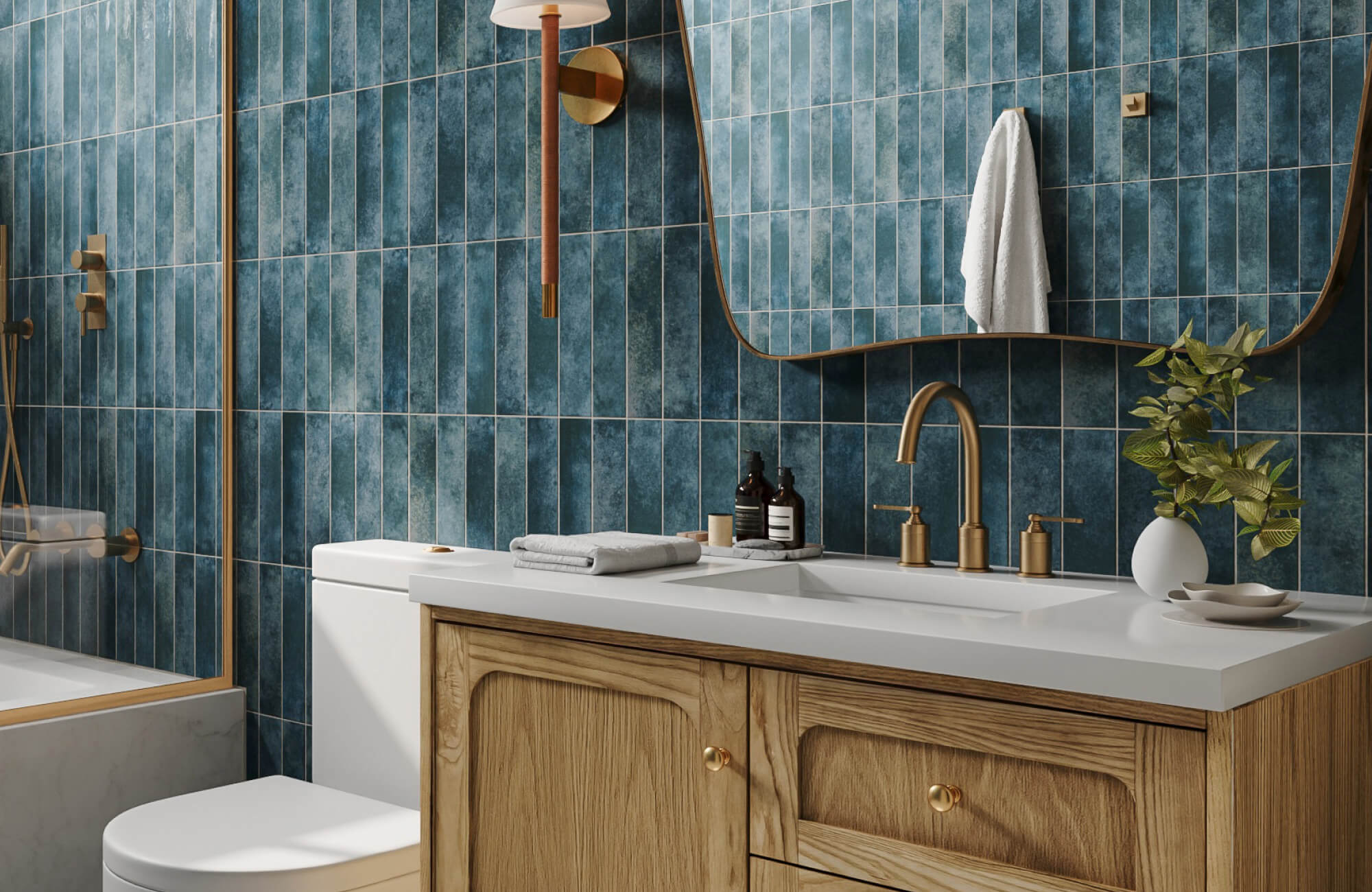 Chic bathroom with zellige-style blue vertical tile backsplash, wood vanity, brass fixtures, sculptural mirror, and modern wall sconce.