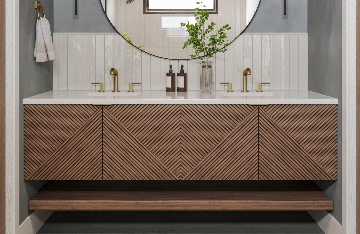 Modern double sink vanity with white vertical tile backsplash and geometric wood paneling in a chevron pattern.