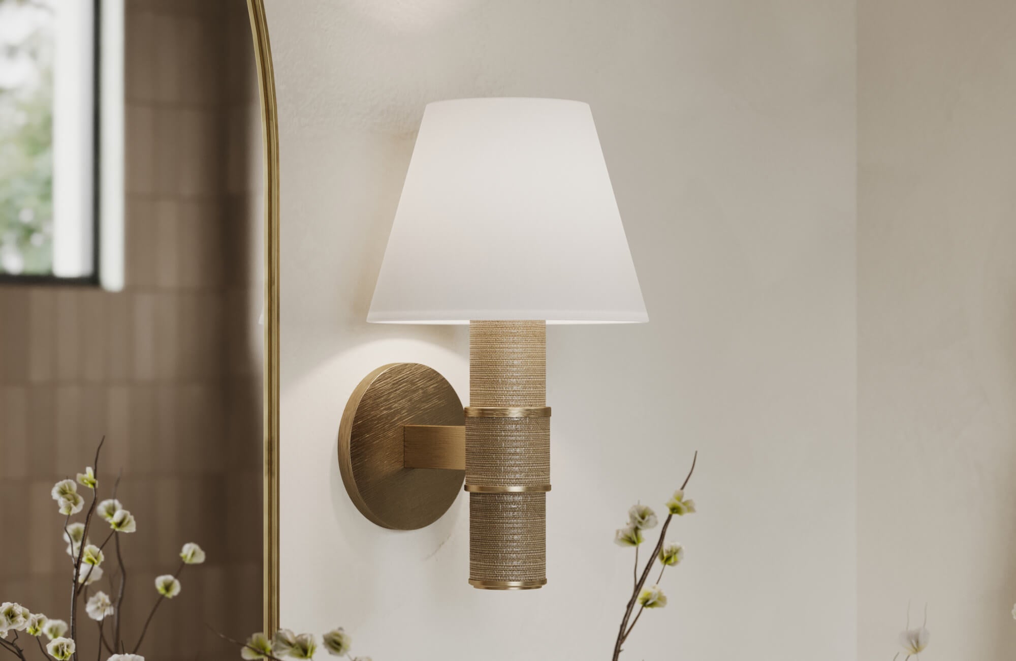 Elegant wall-mounted light fixture with a brass base and tapered white shade, adding warmth to a modern interior.