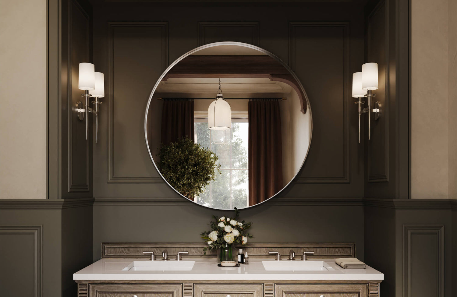 A large round bathroom mirror reflects a warm, elegant interior with paneled dark walls, double sinks, and wall sconces softly illuminating the vanity area.