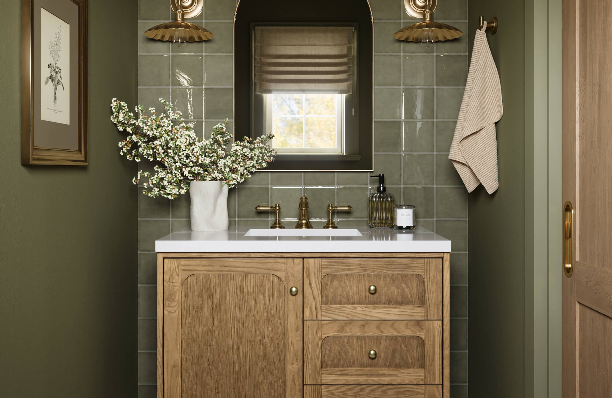 Modern bathroom design featuring a wooden vanity, brass hardware, and olive green tiles accented by a window and wall sconces.