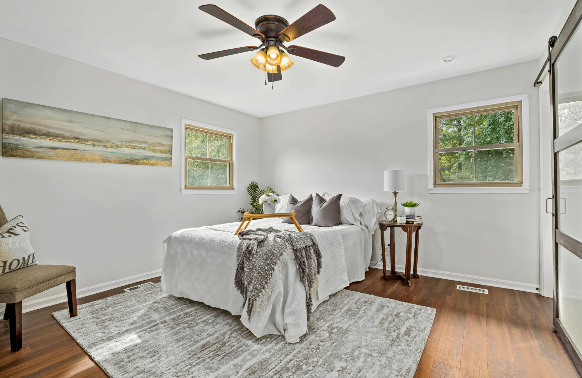 Queen bed centered on a large area rug that extends beyond the sides and foot, creating a balanced and grounded bedroom layout.