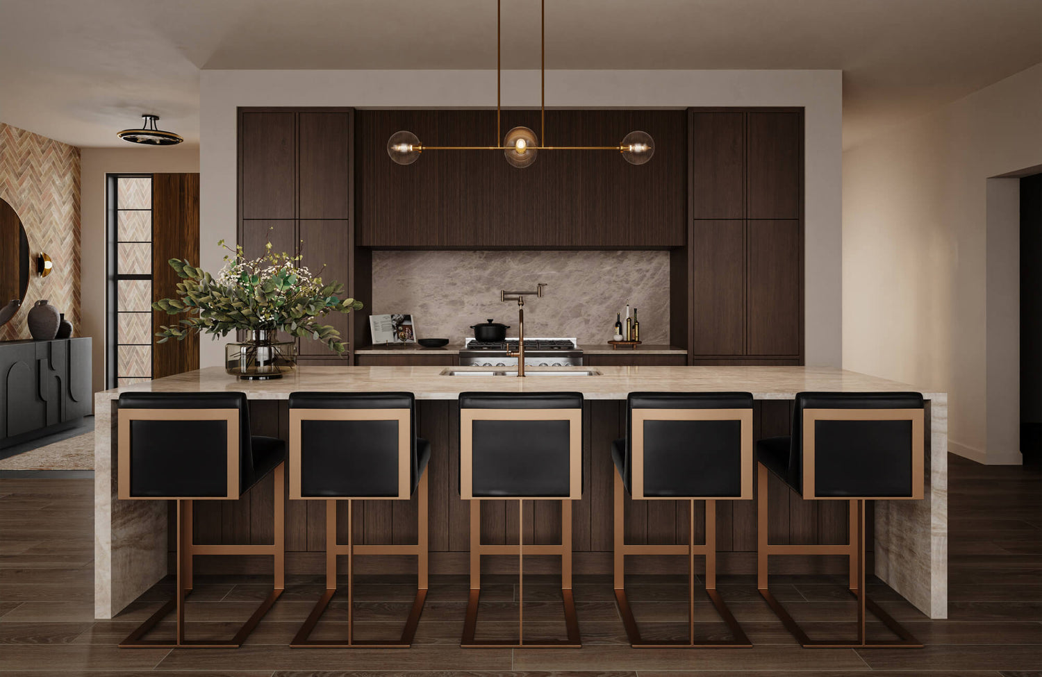 A sleek kitchen island with black leather stools framed in bronze sits beneath a linear brass light fixture, surrounded by dark wood cabinets and a soft marble backsplash.