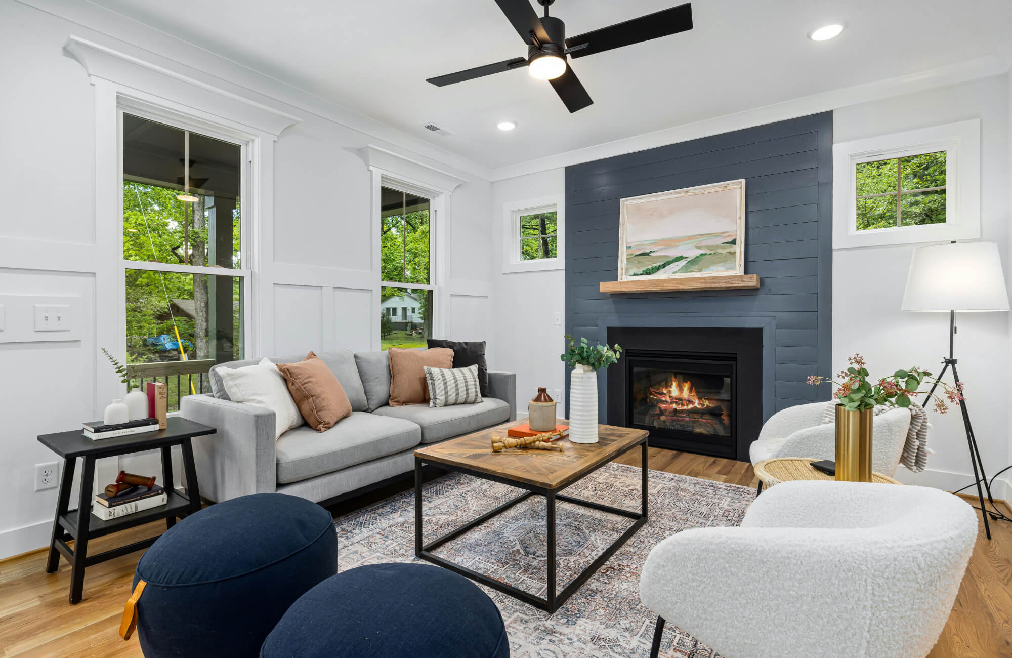 Modern living room with gray sofa and warm-toned throw pillows layered in varying textures and sizes, demonstrating how to mix neutrals and earthy accents for a balanced look