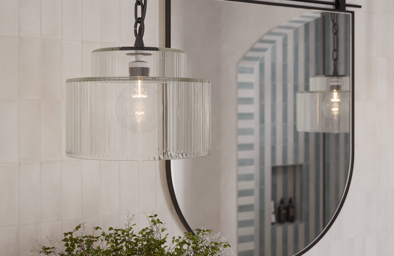 Elegant bathroom mirror paired with a ribbed glass pendant light fixture, creating a refined balance of modern illumination and timeless design.