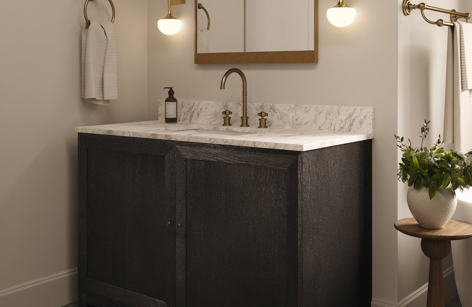 Stylish bathroom vanity in rich black finish with marble top and brass accents, highlighted by soft lighting and minimal decor.