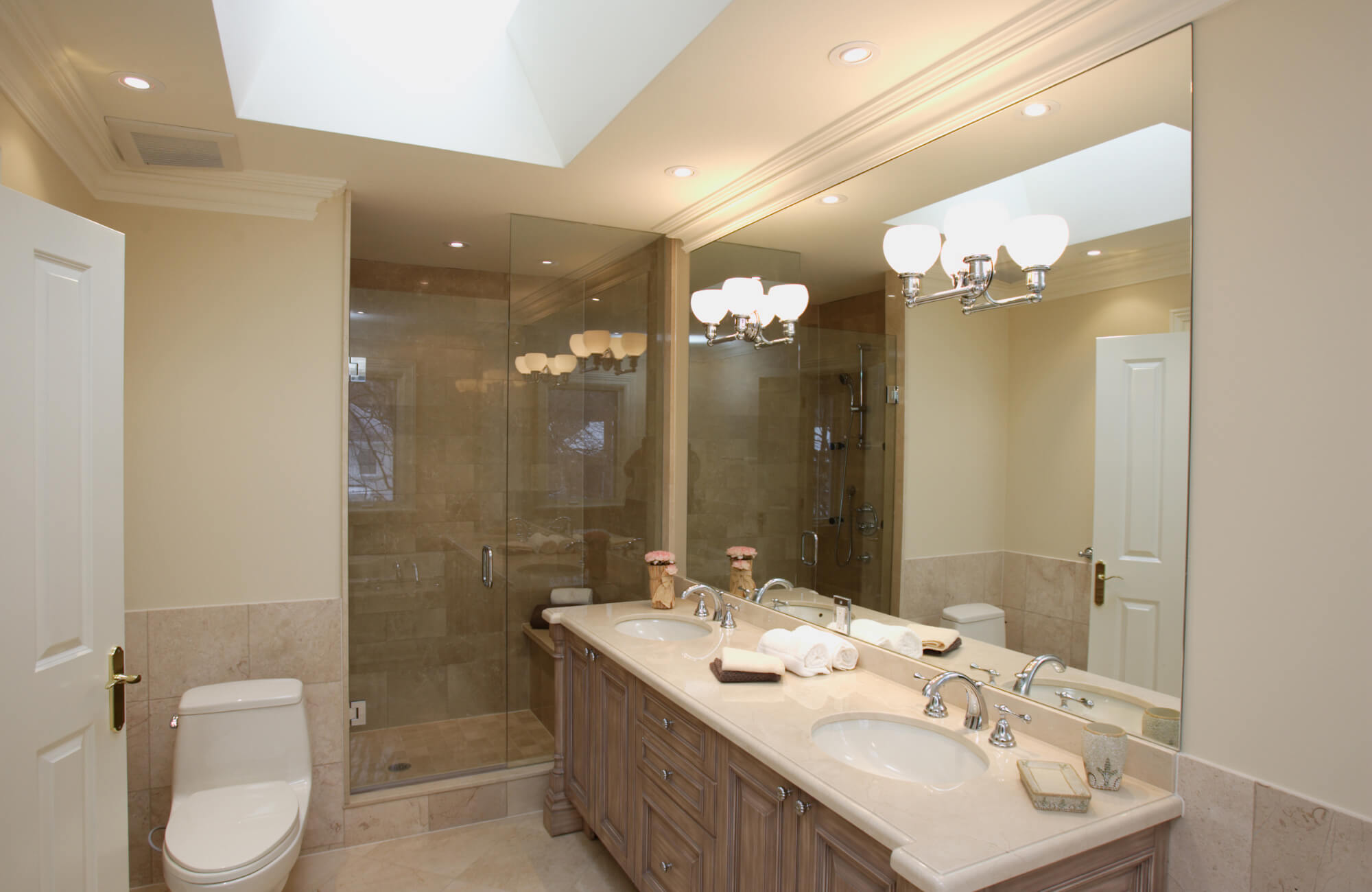 Traditional master bathroom with double sink vanity, marble countertop, framed mirrors, and glass shower in a classic layout.