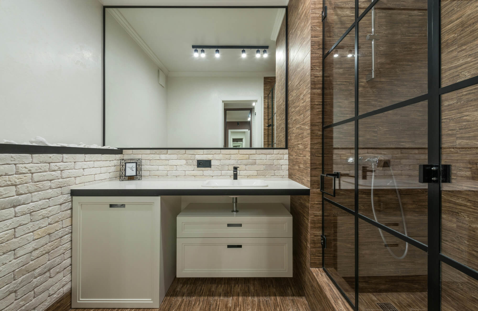 Bathroom vanity with white brick-look tile wall, showing how decorative brick surfaces work in moisture-prone spaces.