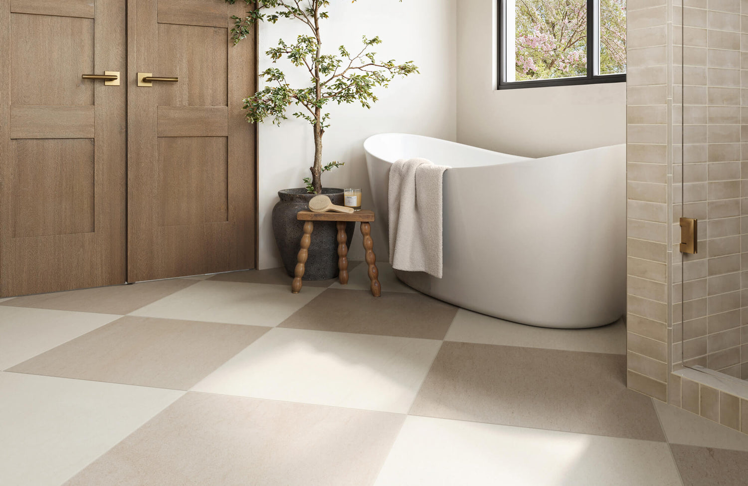 Eco-conscious bathroom with large beige and cream checkerboard tiles, a sculpted tub, and calming neutral décor