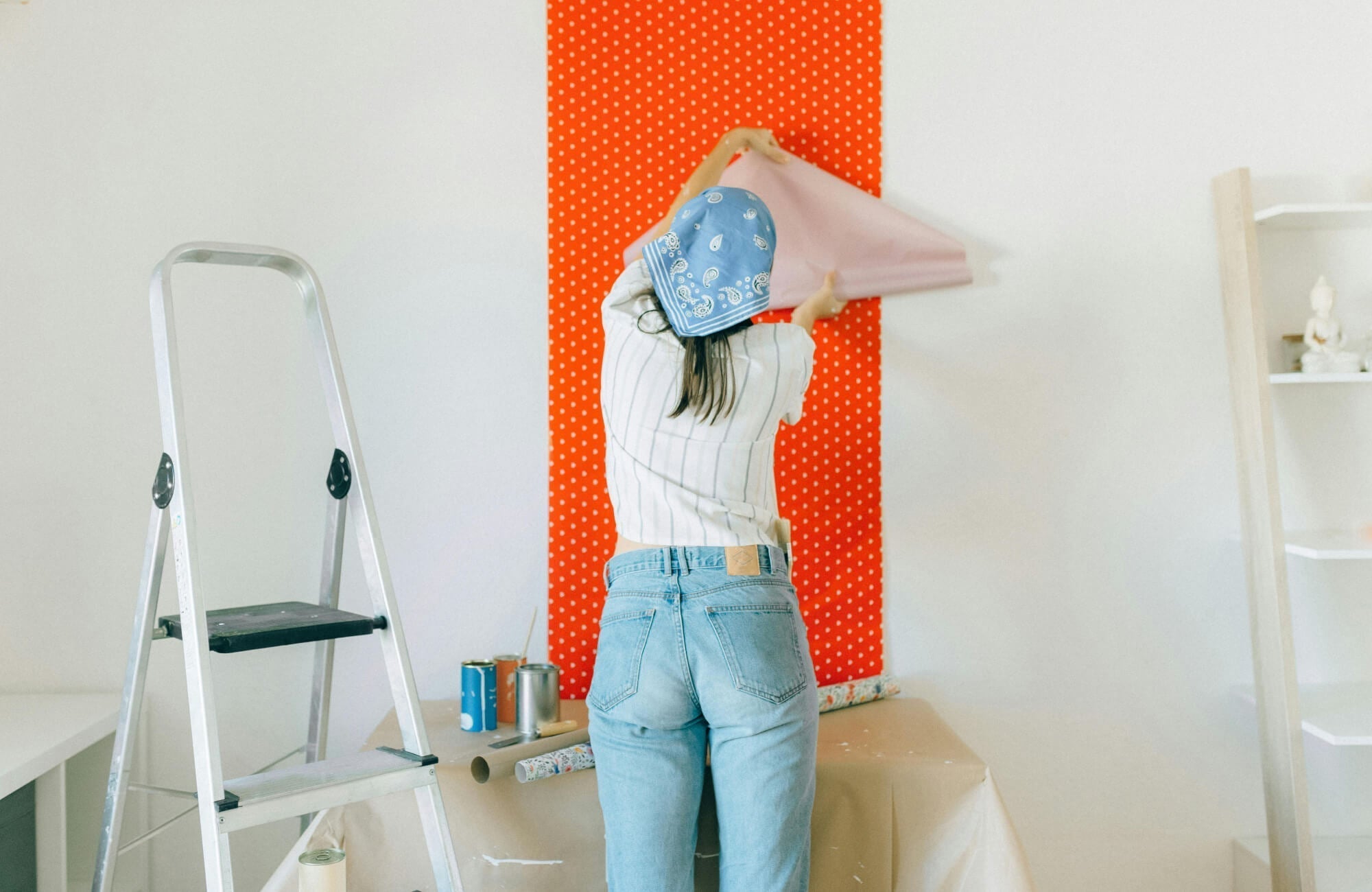 A peel-and-stick wallpaper in bright red adds a playful focal point, showing how easy-to-remove, durable designs can refresh a space without long-term commitment.