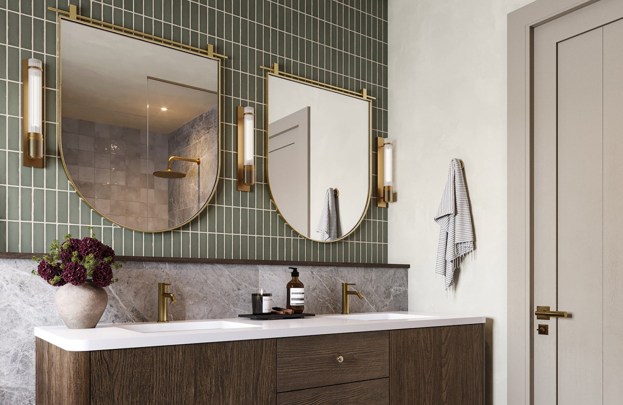 Double sink vanity with dark wood base, gold faucets, and arched mirrors in a modern bathroom with green tile wall.