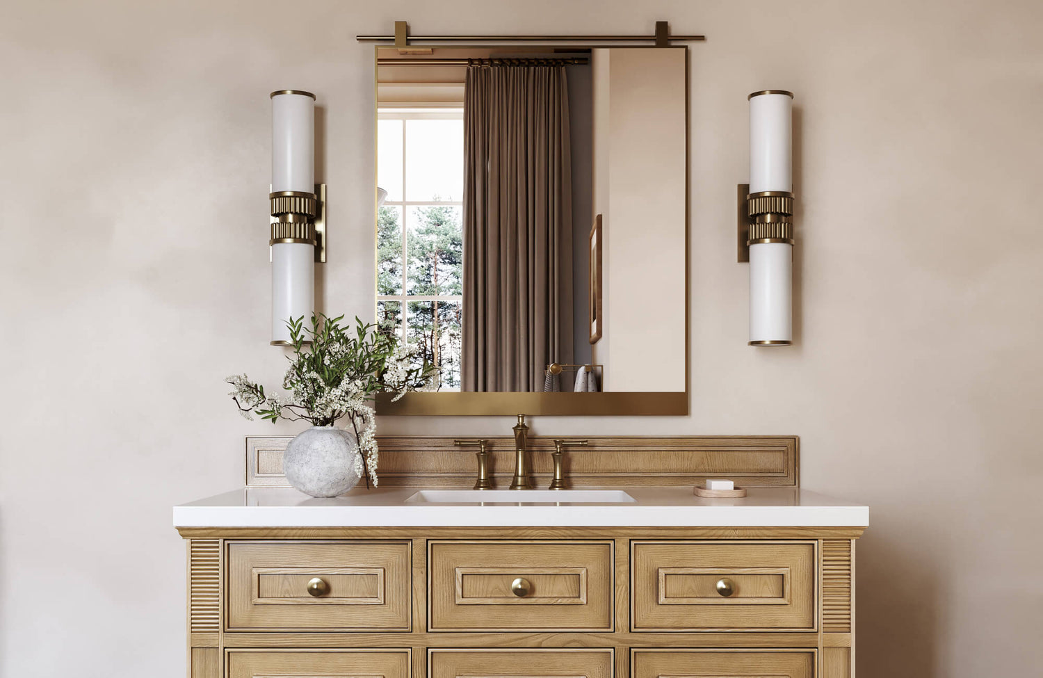 Elegant bathroom vanity with natural wood cabinetry, a sleek gold-framed mirror, and modern sconces against soft beige walls.