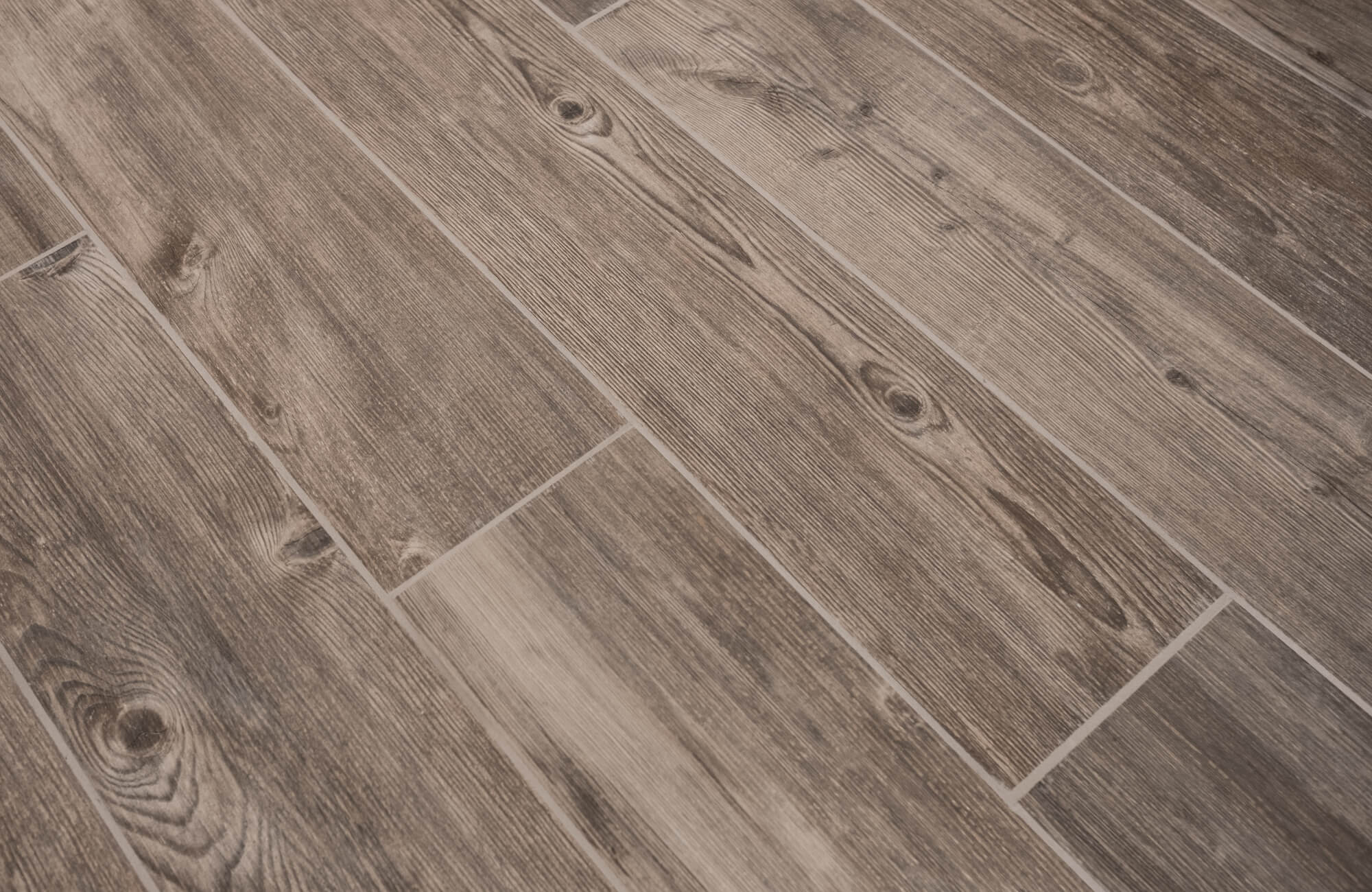 Wood look tile floor installed in a staggered pattern, showcasing natural grain variation and realistic plank movement across the surface.