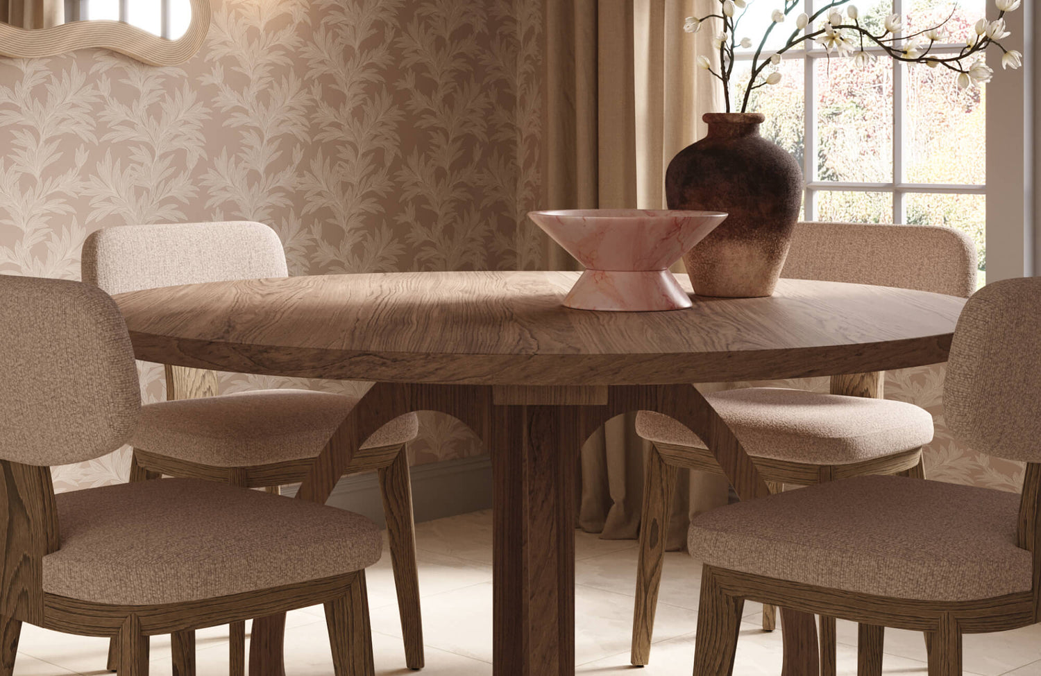 Warm dining nook with a round wood table, upholstered dining chairs, a pink marble decorative bowl, and a rustic ceramic vase styled against soft botanical wallpaper and natural light. 