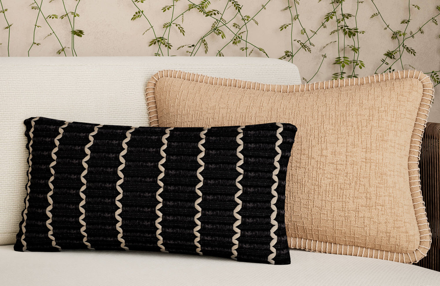 Close-up of a rectangular pillow with textured fabric and a thick, looped trim edge, paired with a patterned lumbar pillow featuring a clean, piped edge for contrast.