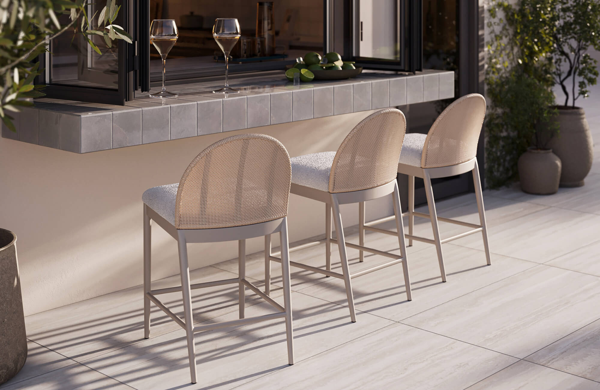 Outdoor counter stools with woven backs and cushioned seats arranged along a tiled bar for relaxed open-air dining