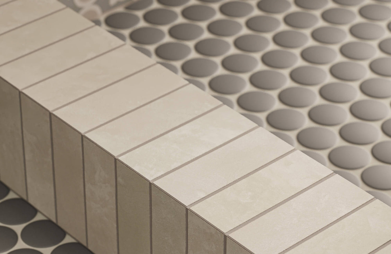 Neutral-toned bathroom step detail showcasing soft gray penny round tile flooring paired with a clean-lined porcelain tile edge, creating subtle contrast, texture, and a refined, modern transition.