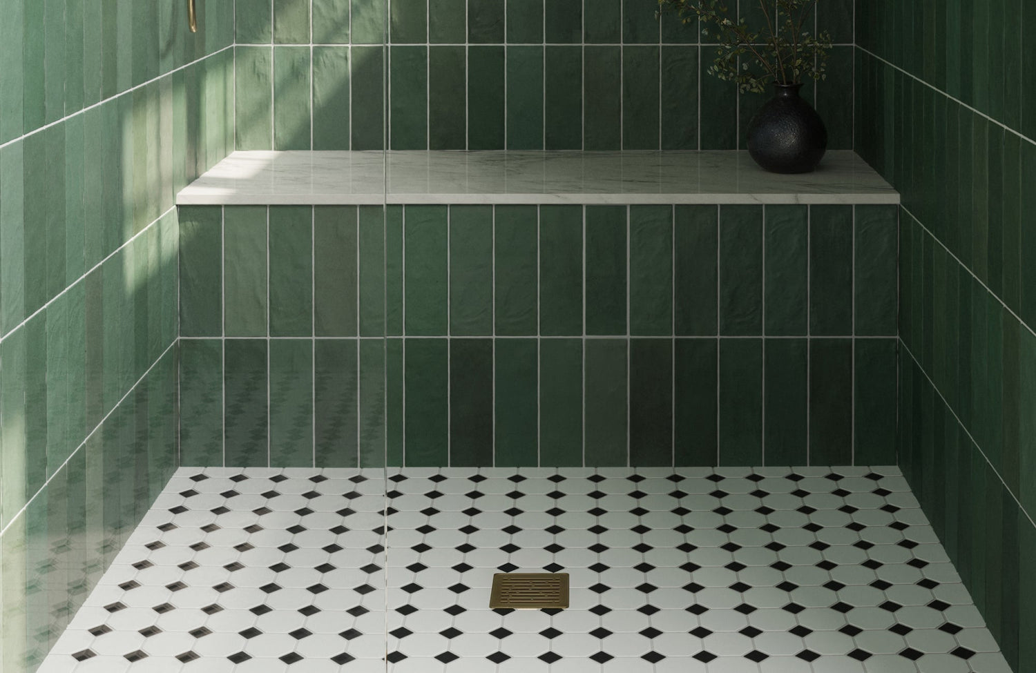 Green shower walls with black and white tile floor create a fresh, natural balance that feels calm and grounded.