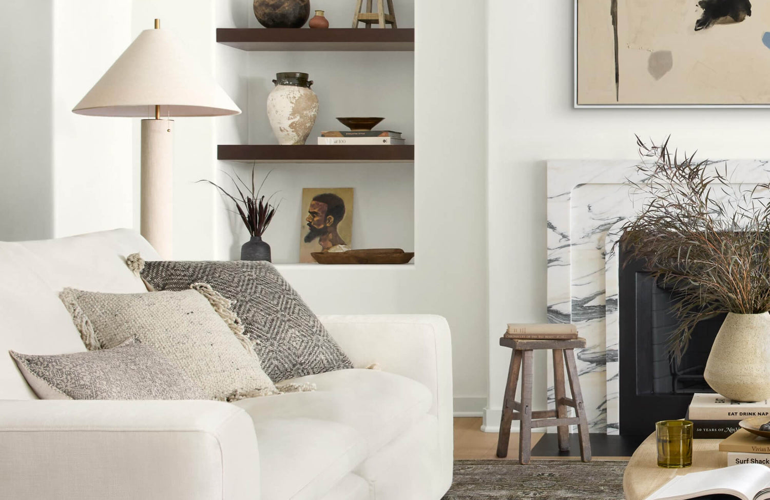 Cozy neutral interior with textured decorative throw pillows and styled wall shelving decor that gives a calm and serene setting.