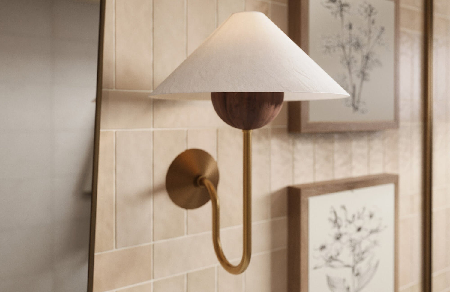Wall sconce with soft brass finish and fabric shade casting warm, diffused light against textured tile for a calm farmhouse feel.