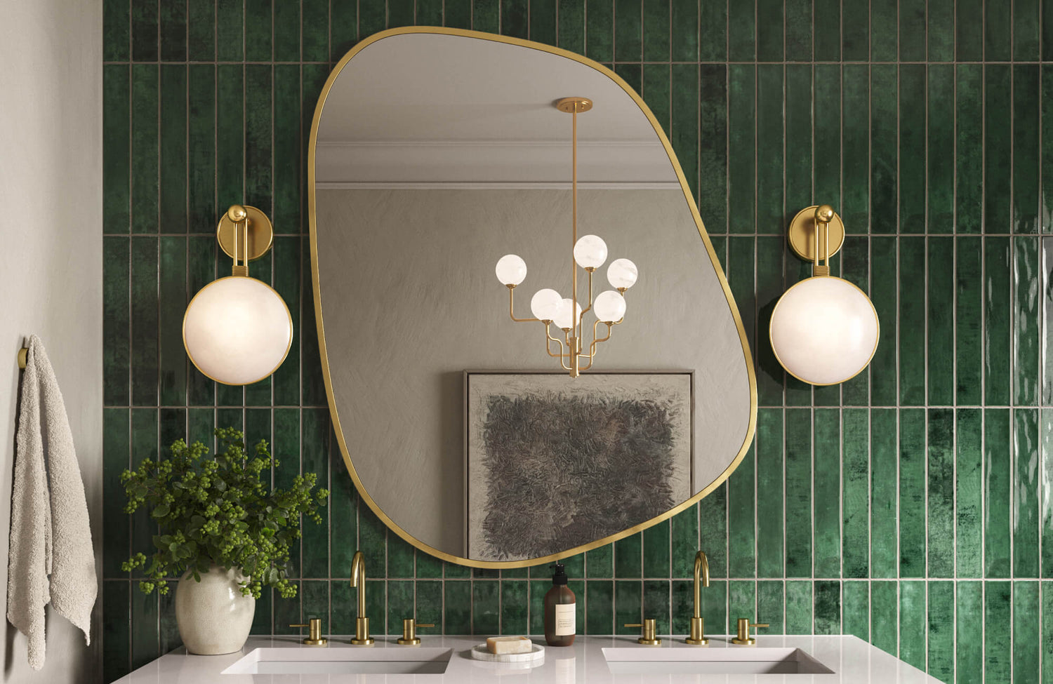 Bathroom with green vertical tiles, gold fixtures, globe sconces, and an organic mirror. 