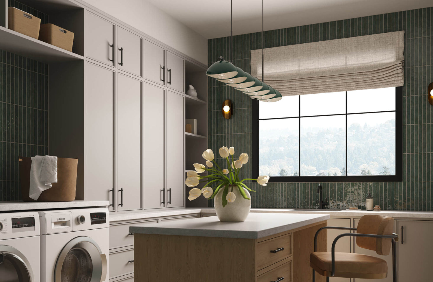 A bright laundry room with tall cabinetry, green vertical tile walls, a central island, and a modern linear light fixture, finished with a large window and fresh tulips.