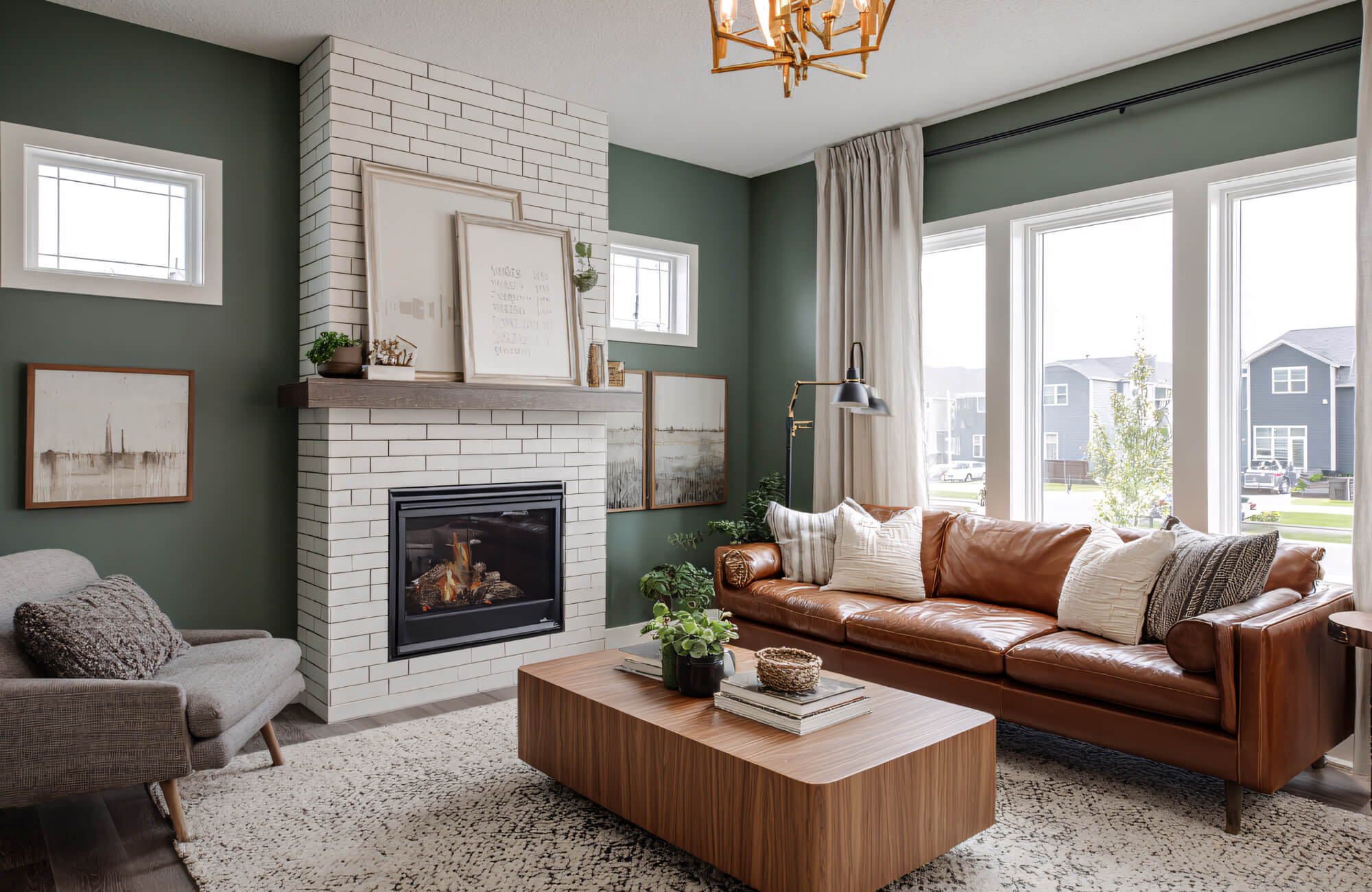Modern living room with a white porcelain tile fireplace surround, warm wood mantel, and green walls creating a balanced, cozy focal point.