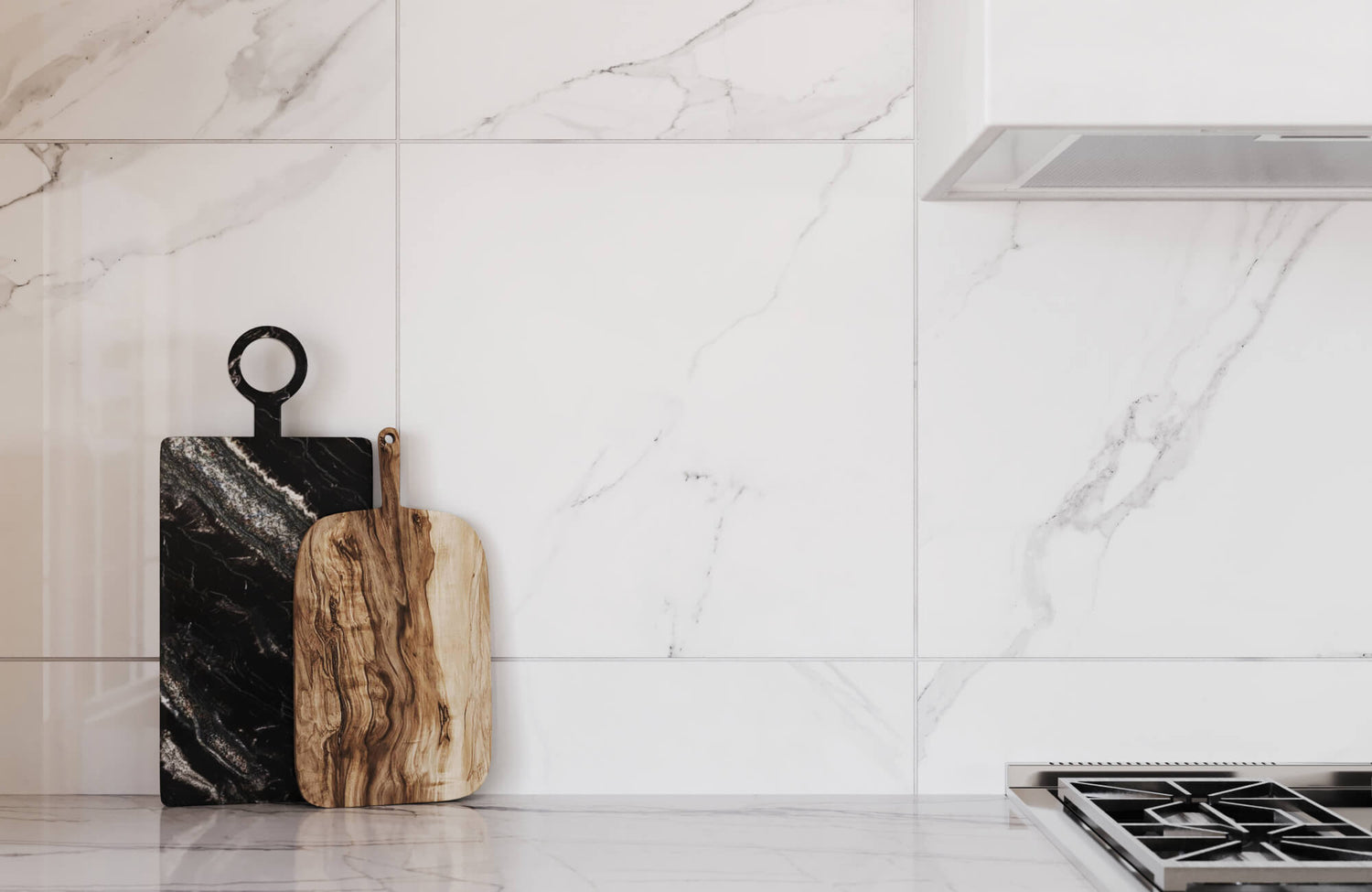 Modern kitchen with sleek white marble effect tiles as a backsplash, accented by two stylish cutting boards in black and natural wood tones.