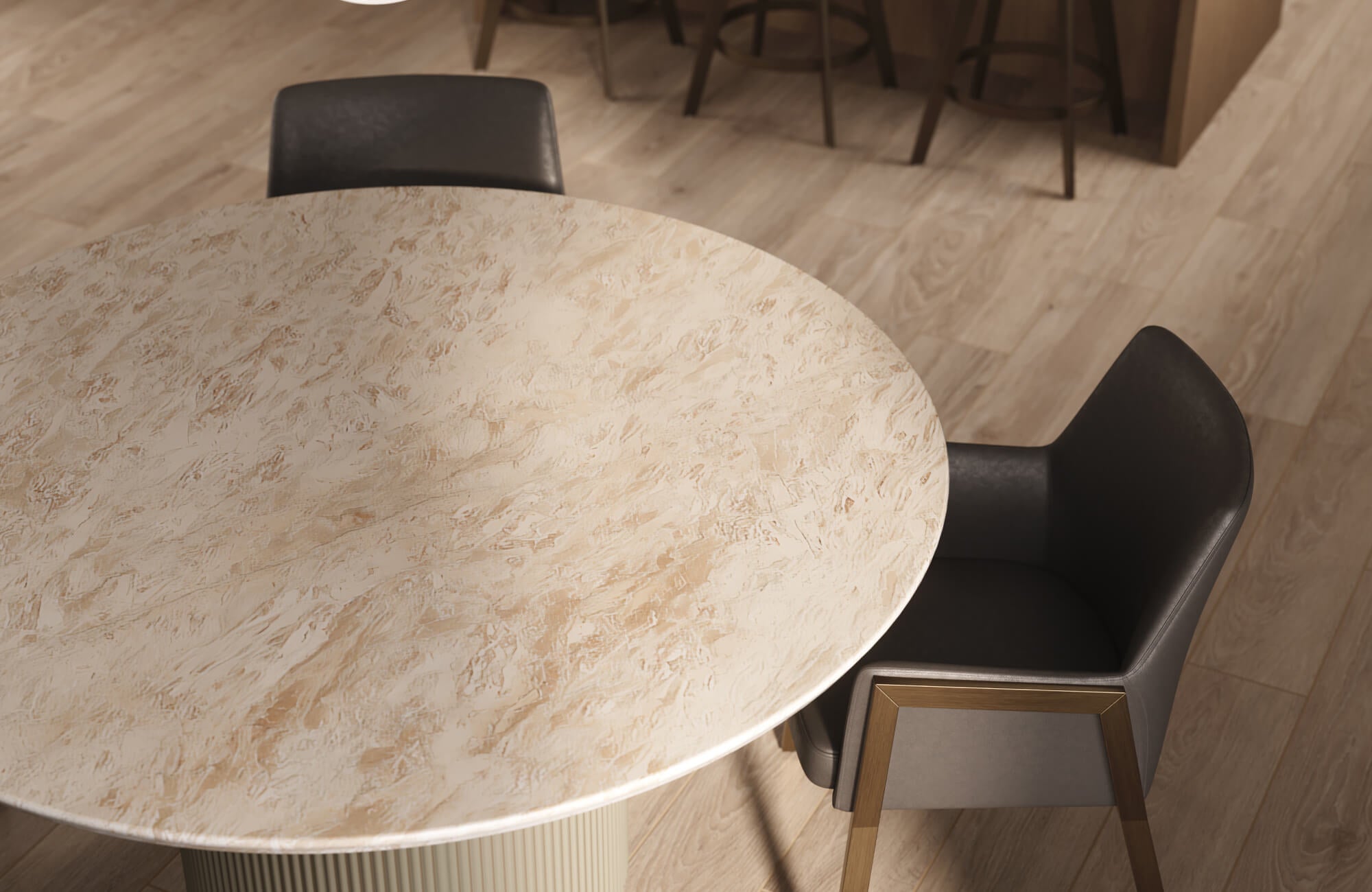 A round dining table with a light beige textured top, paired with a modern dark upholstered chair on warm wood flooring.