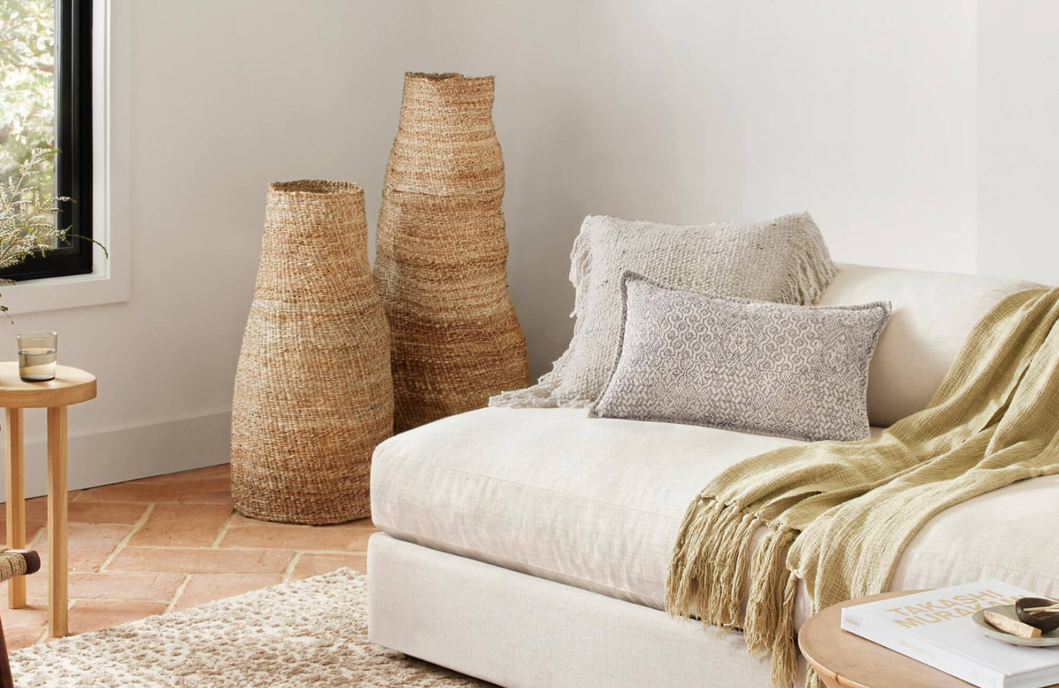 Decorative pillow with subtle geometric pattern styled on a neutral sofa in a warm, minimalist living room setting.