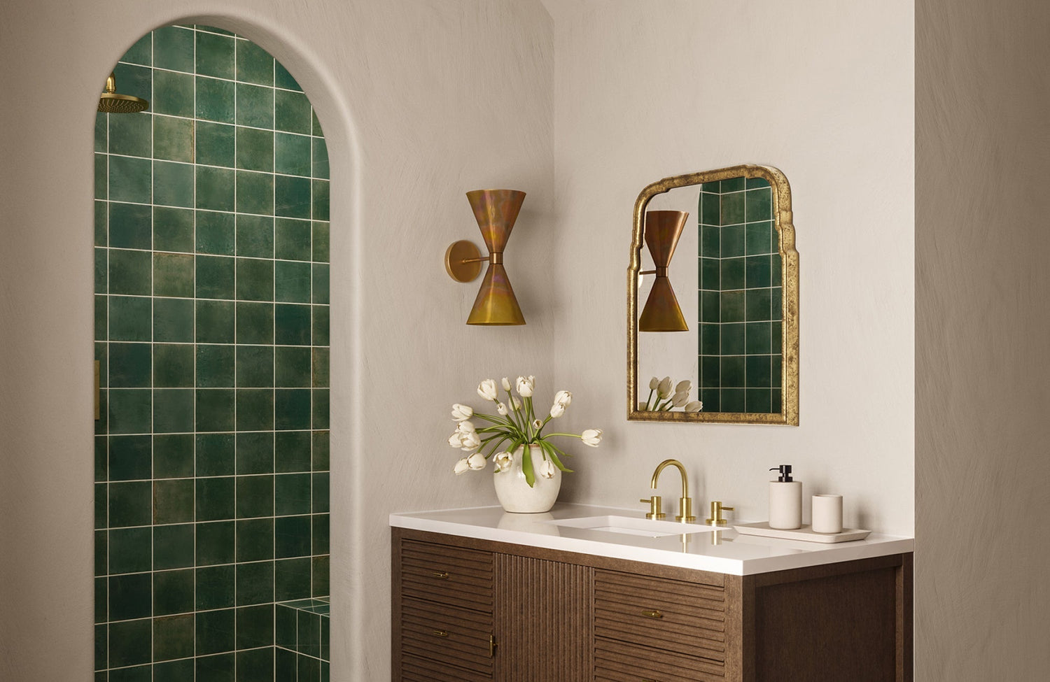 Mirror hung slightly above the faucet, leaving a small gap that anchors it well with the vanity and brass fixtures.