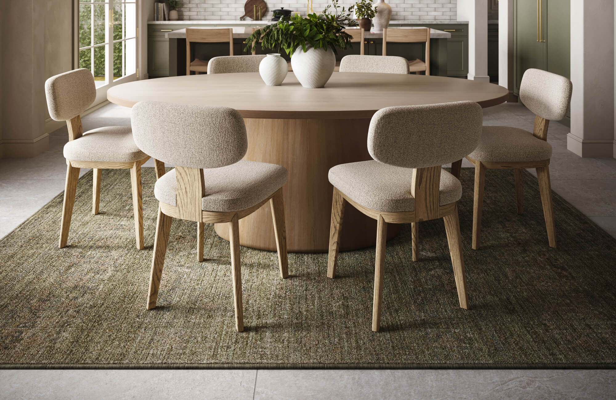 Round wooden dining table with six upholstered chairs on a moss-toned textured rug in a modern kitchen setting.