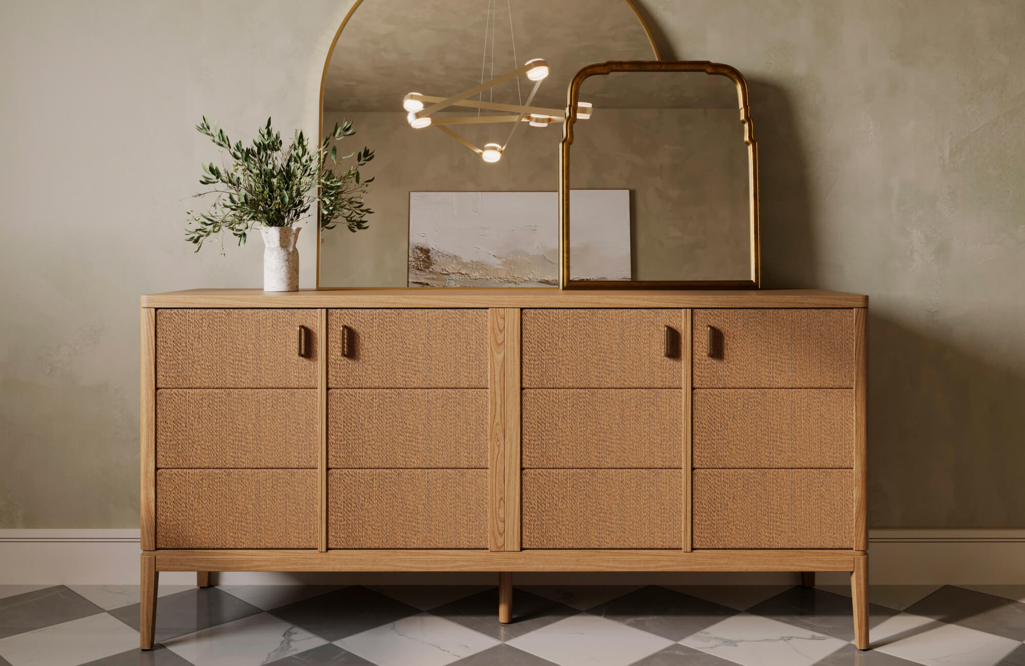 Mid-century oak sideboard with textured drawer fronts and leather pulls, styled with layered mirrors and ceramic vase decor.