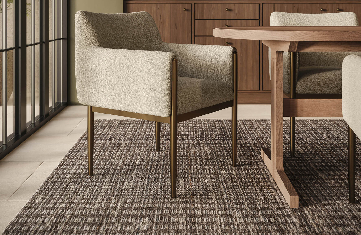 A woven wool rug with tonal brown variation extends beneath the dining table, bringing depth, comfort, and natural texture to the interior.