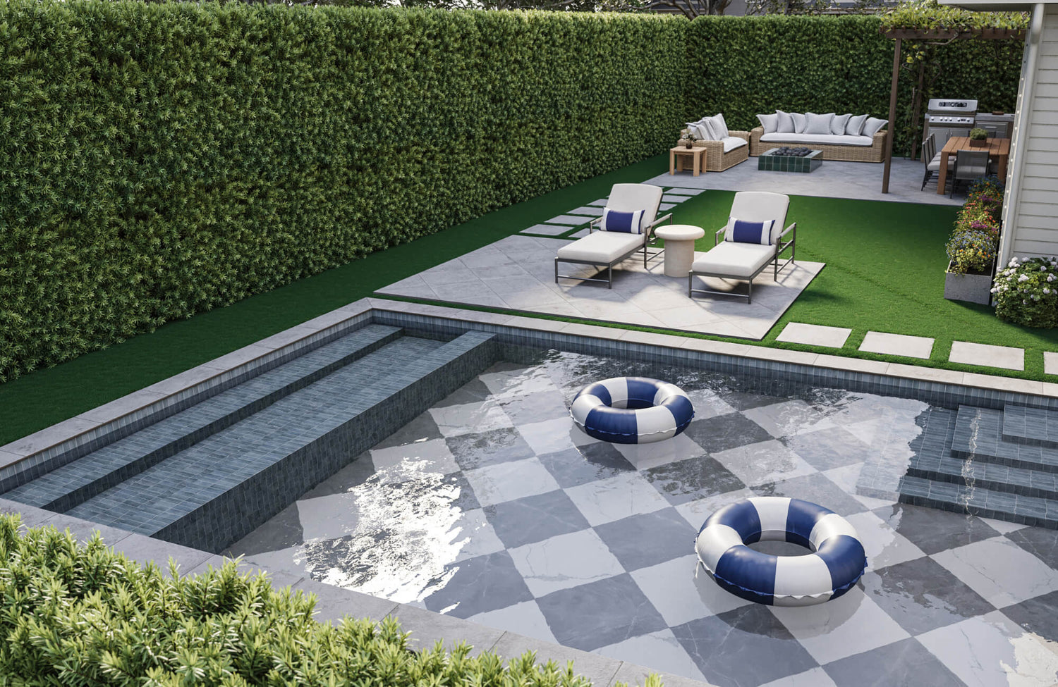 Modern outdoor poolside with tiled water feature, lounge chairs, and lush hedge backdrop designed for year-round durability.