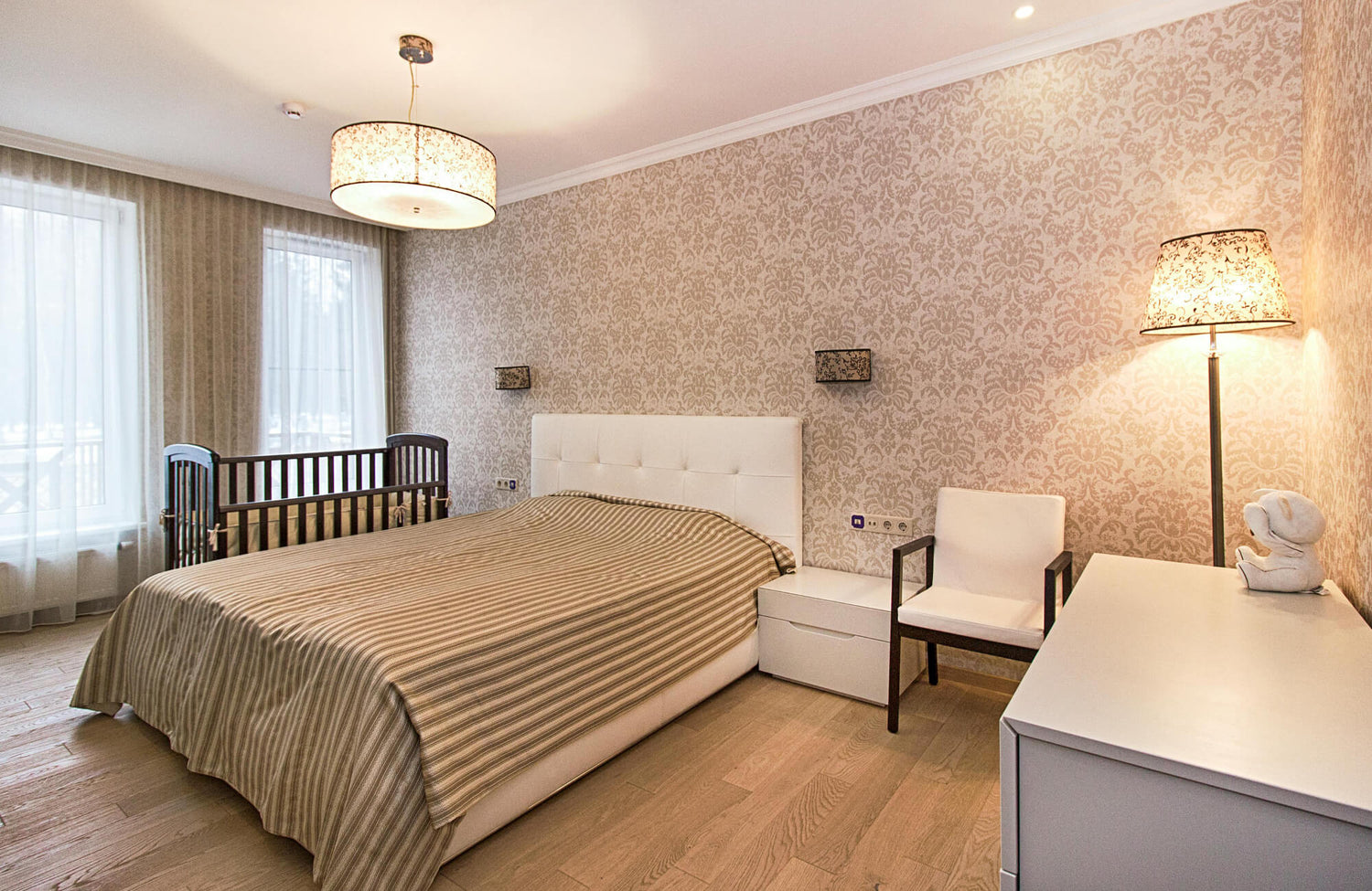 Bedroom with warm beige damask wallpaper creating a soft, classic, and calming atmosphere.