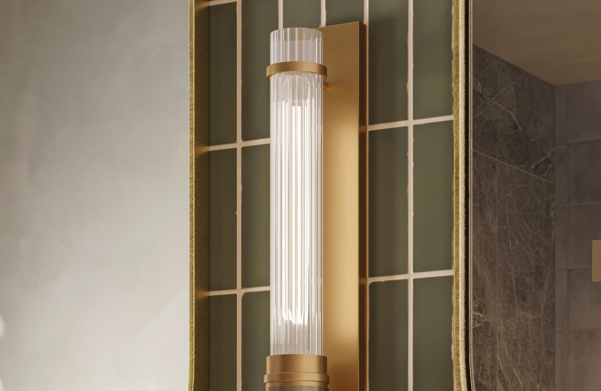 Close-up of a modern bathroom wall sconce with a ribbed glass shade and brass mount.