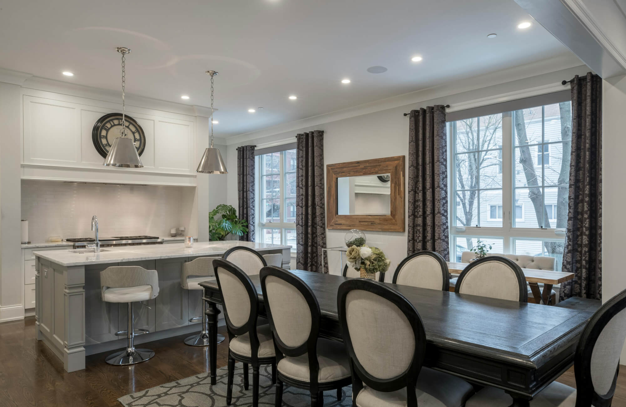 Dining room mirror placed beside the table reflecting light and seating, creating balance and visual openness in a modern layout.