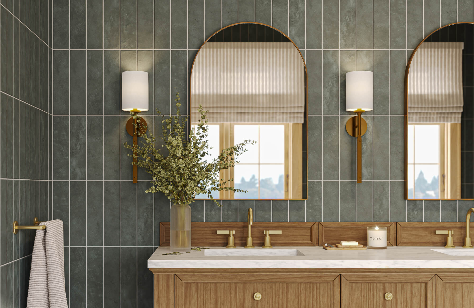 Arch mirror centered above bathroom vanity with brass sconces and green tiled wall backdrop