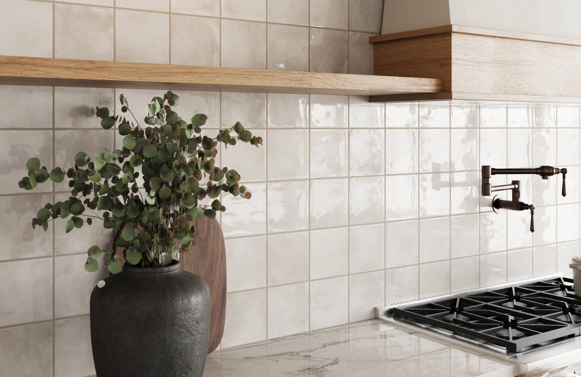 Warm-toned cream and ivory ceramic tiles with a glossy finish, paired with a marble counter and matte black faucet fixture.
