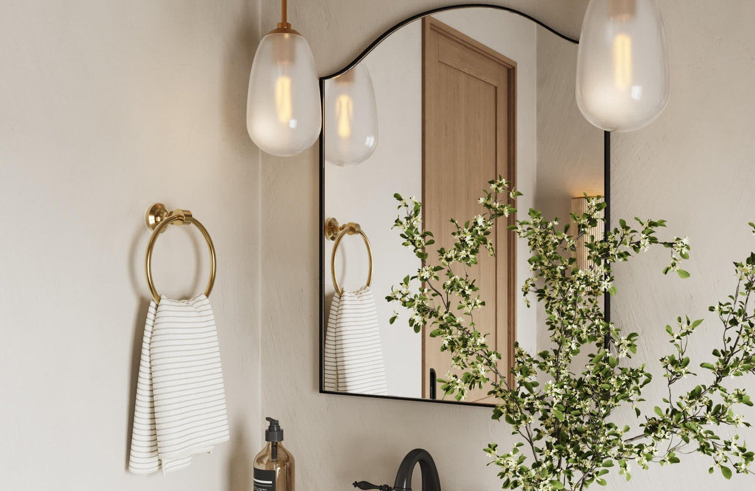 Arched mirror with a slim black frame reflecting warm ambient light, adding softness and architectural charm to the modern bathroom setting.