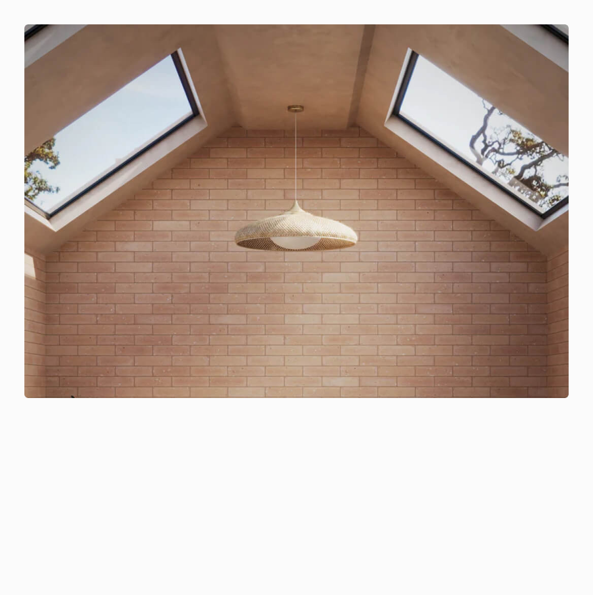 Vaulted ceiling with skylights casting natural light on warm brick-look wall tiles